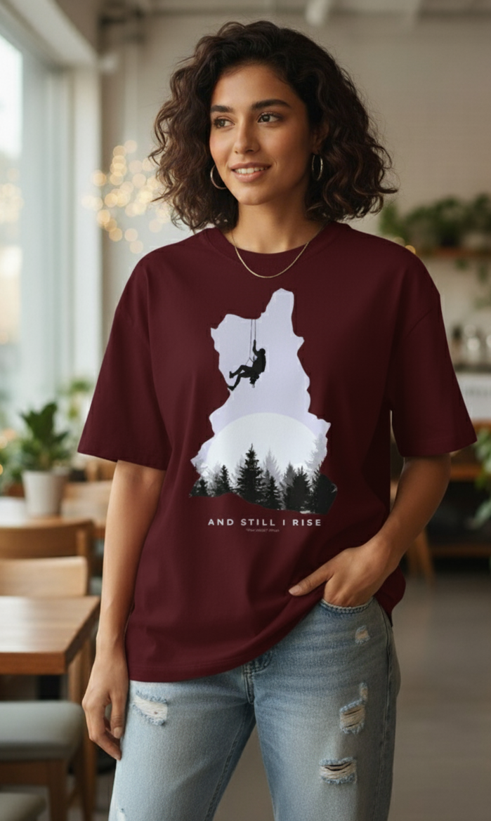 Woman wearing Maroon oversized unisex t-shirt with mountain climber silhouette and forest graphic – And Still I Rise print by The Smoky Skull Front