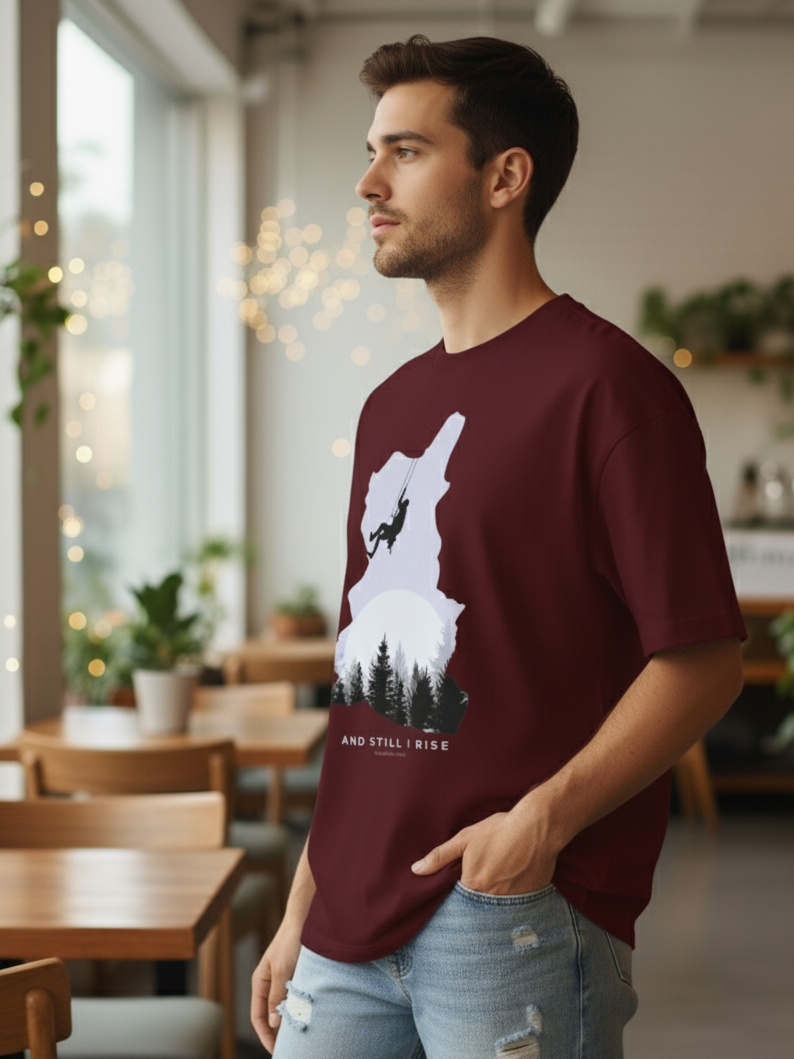 Male wearing Maroon oversized unisex t-shirt with mountain climber silhouette and forest graphic – And Still I Rise print by The Smoky Skull side