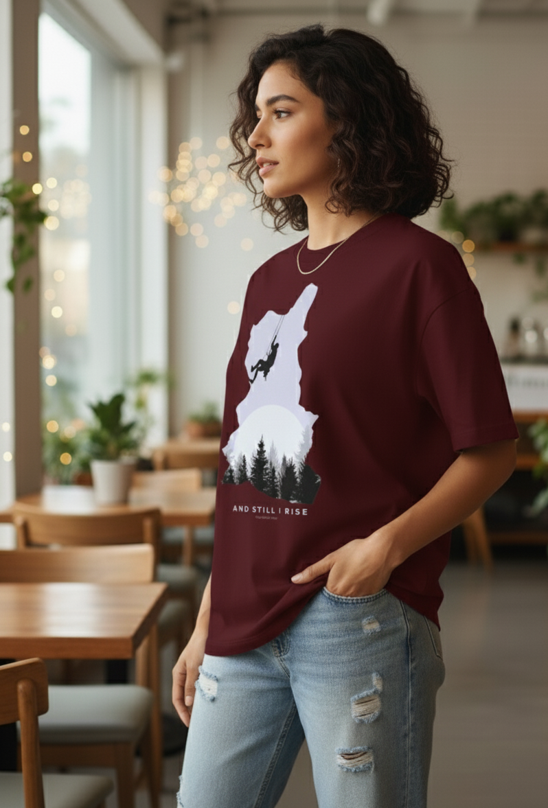Woman wearing Maroon oversized unisex t-shirt with mountain climber silhouette and forest graphic – And Still I Rise print by The Smoky Skull Side