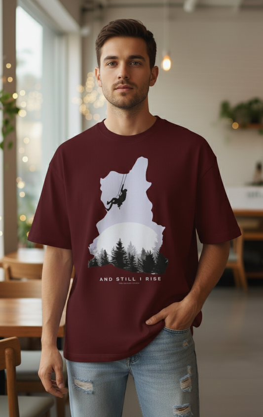 Male wearing Maroon oversized unisex t-shirt with mountain climber silhouette and forest graphic – And Still I Rise print by The Smoky Skull Front