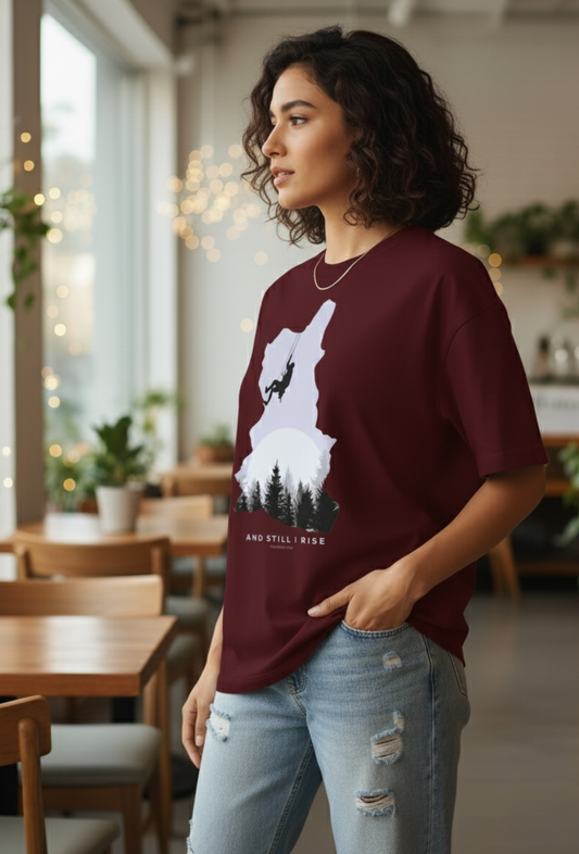 Woman wearing Maroon oversized unisex t-shirt with mountain climber silhouette and forest graphic – And Still I Rise print by The Smoky Skull Side